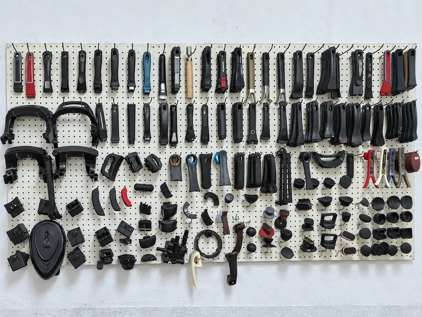 Handles and cookware components arranged on a display wall