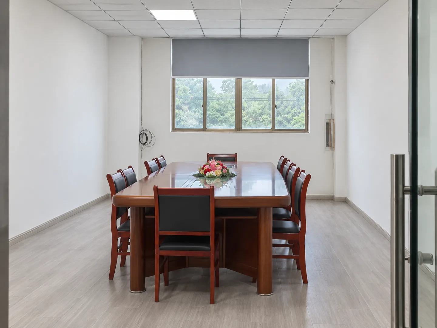 Wooden meeting table and chairs beside a window